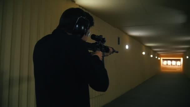 Shooting gallery. A young man aiming using a rifle and shooting — Stock Video