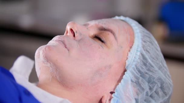 Güzellik Kliniği. Krem üzerinde genç kadın yüz kuru alır — Stok video