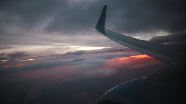 Concepto de viaje. Vista desde la ventana del avión al hermoso amanecer o atardecer. Ala de avión y nube en el cielo . — Vídeos de Stock