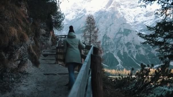 Dolomitas. Camino de montaña. Una mujer camina hacia arriba sosteniendo la barandilla — Vídeos de Stock