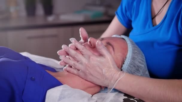 美容诊所年轻女子得到一个放松的抗衰老面部按摩 — 图库视频影像