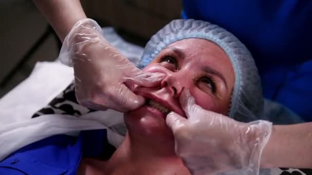 Clínica de beleza. Mulher jovem recebendo uma massagem facial anti-envelhecimento. Massagear dobras nasolabiais . — Vídeo de Stock