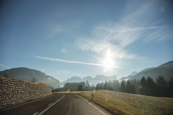 Viaja en coche por las montañas. Una vista desde el coche en la carretera. Día soleado — Foto de Stock