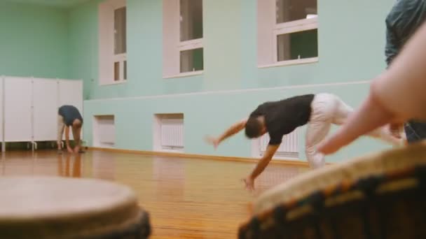 Přehrání jembe dvou hudebních nástrojů nebo atabaque na pozadí mužský stíhací provádí bojové triky s taneční prvky — Stock video