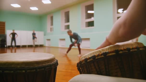 Граючи на музичних інструментах джембе або атабаке на фоні чоловічий боєць виконує бойові трюки з елементами танцю — стокове відео