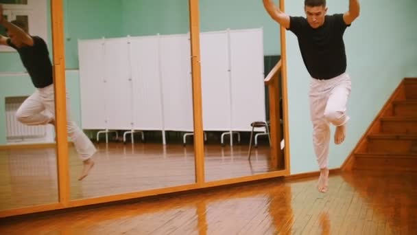 Tiro de lutador masculino executa truques marciais com elementos de dança no treinamento de capoeira — Vídeo de Stock