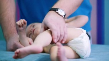 Tıp Kliniği. Serebral felç bozukluğu olan küçük bir bebek iken kendi ayakları üzerinde yapıyor Doktor tıbbi bir kanepede yatıyor