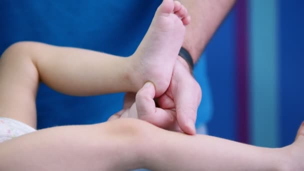 Medical centre. A doctor works with a baby with cerebral palsy disorder. Doing physical exercises on legs — Stock Video