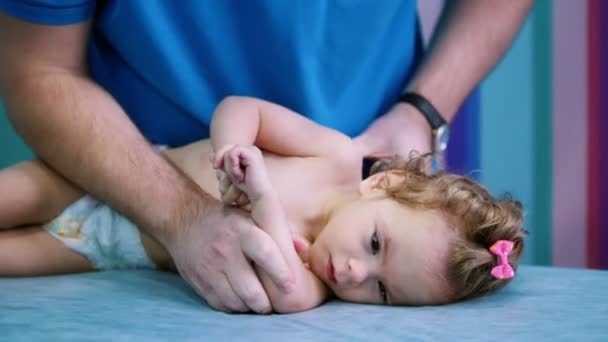 Ιατρικό κέντρο. Ένας γιατρός κάνει ασκήσεις με ένα μικρό μωρό με εγκεφαλική παράλυση διαταραχή — Αρχείο Βίντεο