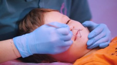 Tıp Kliniği. Beyin felci hastalığı olan bir bebek. Konuşma terapisi masajı, özel araç ile bir kadın çalışıyor. Yakın çekim