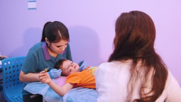Clínica médica. Un bebé con parálisis cerebral. Masaje de fonoaudiología, una mujer trabaja con un instrumento especial — Vídeo de stock