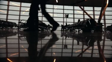 Siluetleri yolcuları Havalimanı Dış Hatlar Terminali içinde. Etrafta dolaşan insanlar.
