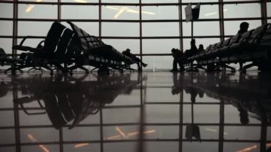 Siluetleri yolcuları Havalimanı Dış Hatlar Terminali içinde. Etrafta dolaşan insanlar. Ayak