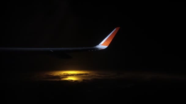Concept de voyage. Vue de la fenêtre de l'avion. Ciel nocturne. Lumière orange au-delà du ciel — Video