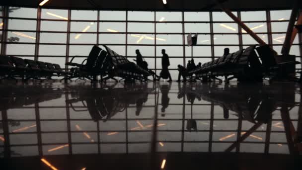 Sziluettek utazók nemzetközi repülőtér. Emberek gyaloglás körül. Láb zár-megjelöl — Stock videók