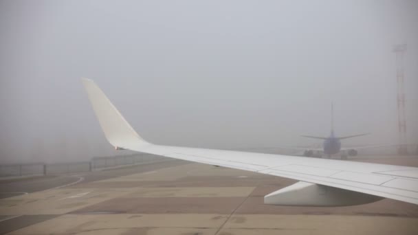 Reisekonzept. Blick aus dem Flugzeugfenster. Flugzeug bei nebligem Wetter gelandet. — Stockvideo