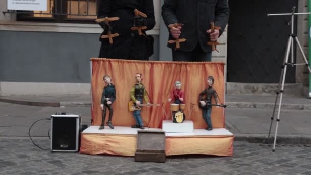 Performance. Puppets plays instruments on the little stage. Two men control the marionettes — Stock Video