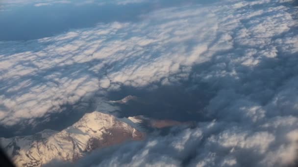 Viajar. Vista da janela do avião. Vista para as montanhas. Nuvens de penas — Vídeo de Stock