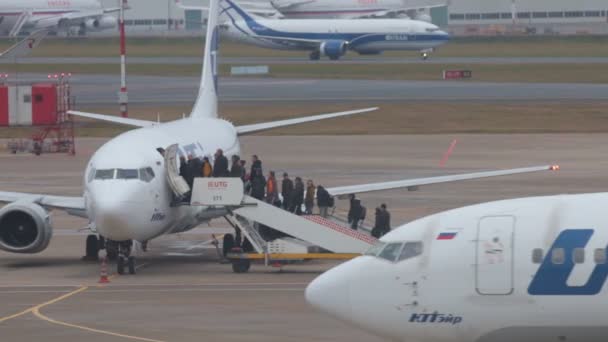 Rusia, MOSCOW. 8-11-2018. AEROPUERTO SHEREMETYEVO: La gente está aterrizando en el avión. Líneas aéreas UGT y UTair — Vídeo de stock