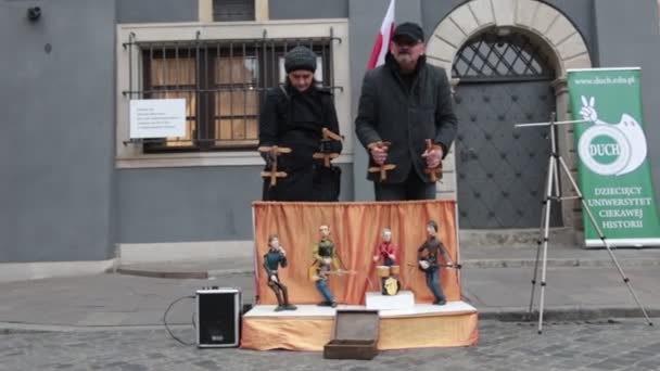 POLÓNIA, GARANTIA 9-11-2018: Performance. Os fantoches tocam instrumentos no pequeno palco. As pessoas controlam as marionetes. — Vídeo de Stock