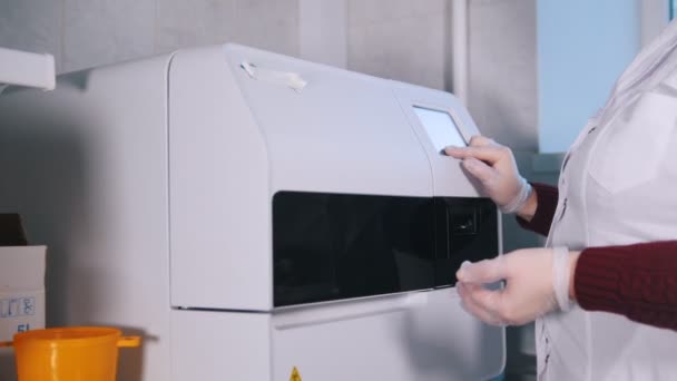 Medical clinic. Nurse works with a special machine for blood analysing. Blood centrifuge — Stock Video