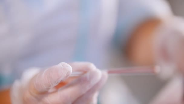 Clinique médicale. Un test sanguin. Goutte de sang sur le verre et broyage de l'échantillon sur le verre. Angle latéral — Video