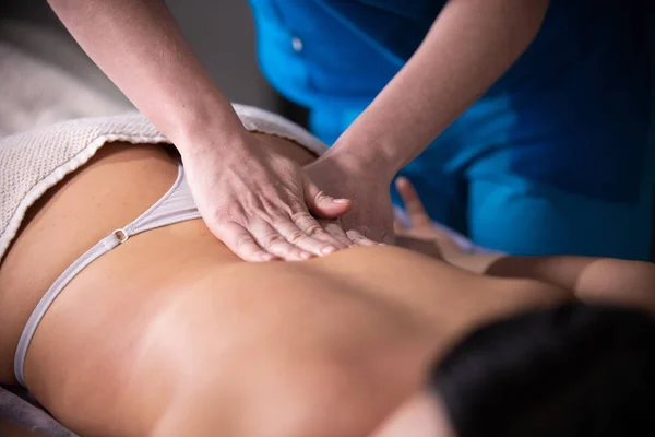 Massage sessie. Een vrouw ontvangen van een massage. Rug massage. Te drukken op de loin — Stockfoto