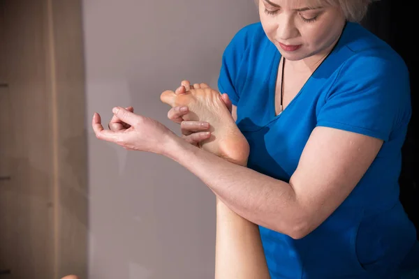Sesión de masaje. Una mujer recibiendo un masaje de pies. Relajando los músculos —  Fotos de Stock