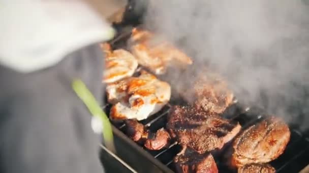 Volteando filetes en la parrilla en el sol — Vídeos de Stock