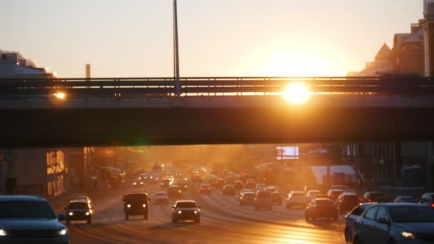 Köprünün altından yolda sürme arabalar. Günbatımı. — Stok video