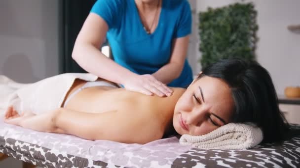 Massage behandeling. Een masseuse bereidt het lichaam voor de massage — Stockvideo
