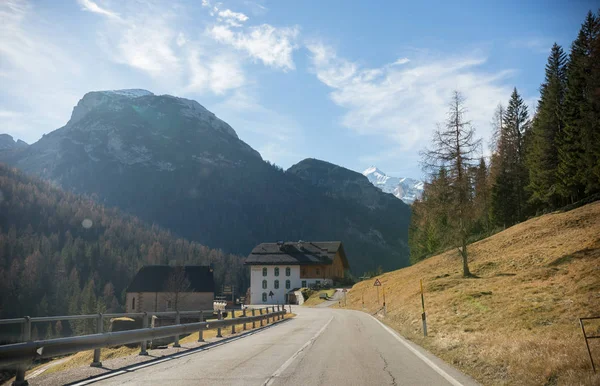 Traveling. A view on mountains, empty road and trees on the side. Motel on the road — Stock Photo, Image