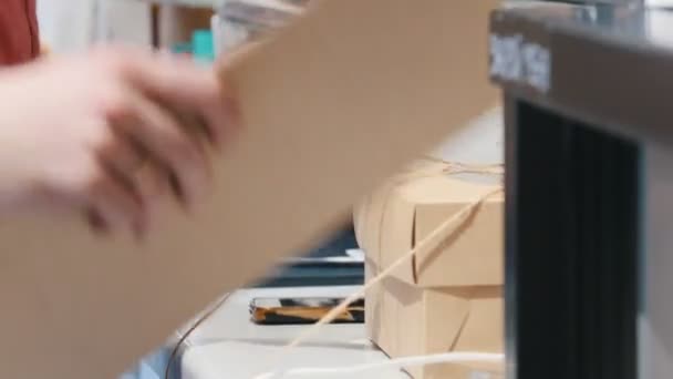 Una panadería. Un hombre empacando el pastel. Sosteniendo una caja de cartón — Vídeos de Stock