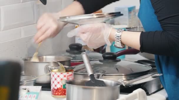 Panadería. Una mujer cocinando en la estufa eléctrica. Agitar algo en la sartén — Vídeo de stock