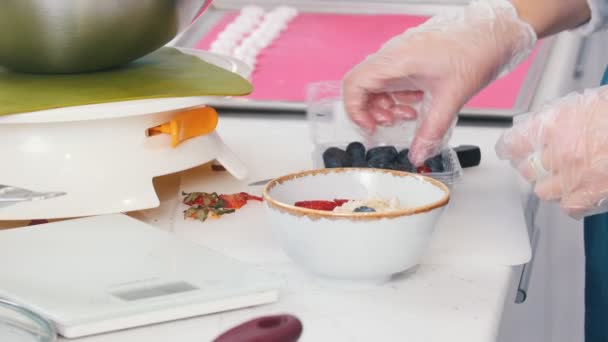 A cafe kitchen. Serving the porridge with berries. — Stock Video