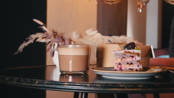 A bakery. A sweet breakfast. A piece of blackberry cake and cup of coffee on the table — Stock Video