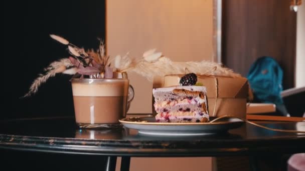 Um pequeno-almoço doce. Um pedaço de bolo de amora e uma xícara de café na mesa — Vídeo de Stock