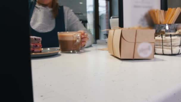 Хлібопекарня. Подача шматочка чорничного торта і чашки кави клієнту на касі — стокове відео