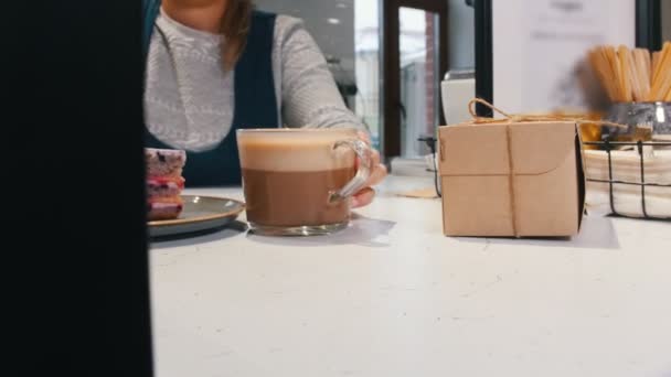 Bäckerei. einem Kunden ein Stück Brombeerkuchen und eine Tasse Kaffee zu geben. — Stockvideo