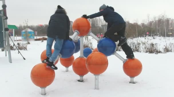 Двое маленьких детей веселятся на детской площадке — стоковое видео
