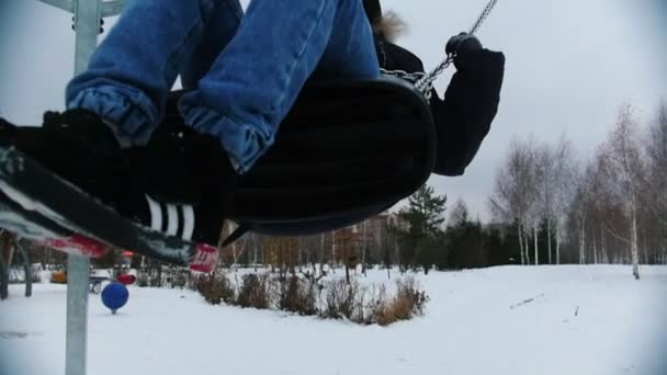 Un chico joven balanceándose en el patio de recreo — Vídeos de Stock
