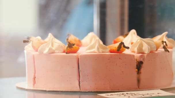 A beautiful pink cake behind the shop window. Close up — Stock Video