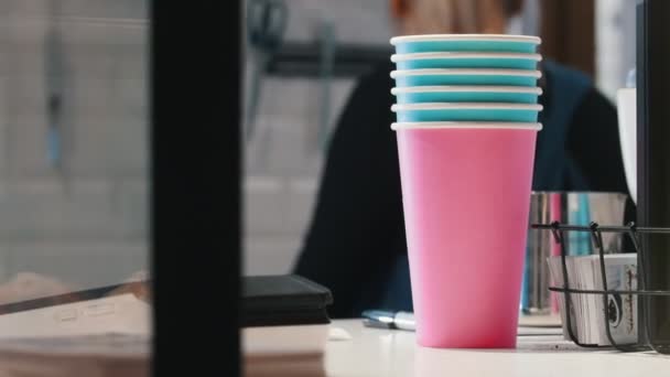 A woman making coffee. Barista. Colorful cups on the foreground. Close up — Stock Video
