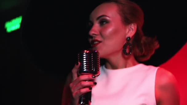 Eine junge attraktive Frau, die auf der Bühne auftritt. Gesang im Publikum — Stockvideo