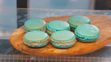 Dükkanı penceresinin arkasına ahşap bir tahta üzerinde mavi macaroons