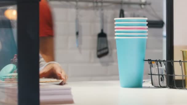 Een stukje chocolade cake en blauwe bitterkoekjes bedienen aan de kassa — Stockvideo