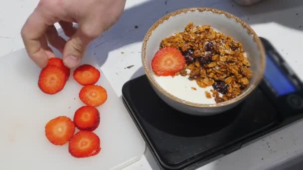 Du yaourt blanc dans le bol. Déposer les fraises — Video