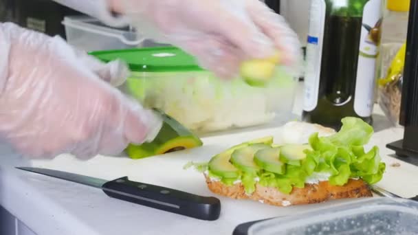 Gezond ontbijt. Het maken van een boterham. Snij een avocado — Stockvideo