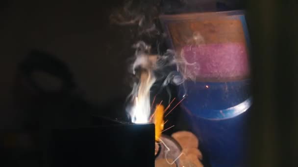 Welding process. A welder in helmet doing his job in the dark. — Stock Video