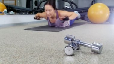 Eğitim. Genç bir kadın karnında döşeme ısınma. Halter ön üzerinde